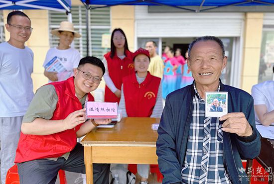 “溫情照相館”攤位上，前來照相的老人與志愿者開心地合影留念_副本.jpg