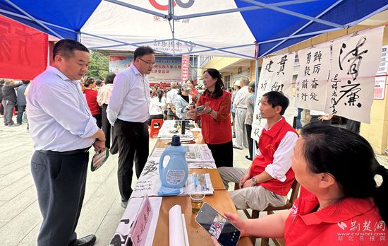 “文化惠民”攤位上，志愿者展示書法作品_副本.jpg